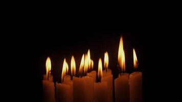 Flames from multiple candles on a black background video