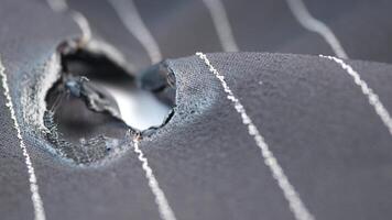 Damaged fabric with a tear displayed under close examination video