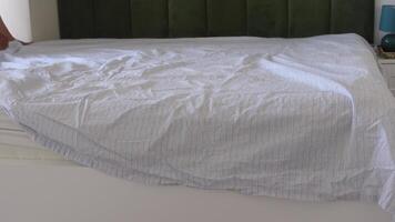 Making a bed with fresh linens in a cozy bedroom setting video