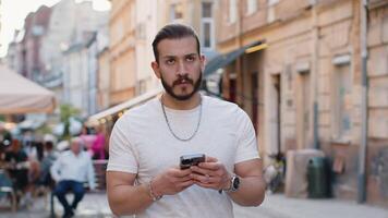 Tourist traveler young man guy using looking smartphone search a way on map in mobile navigator app video