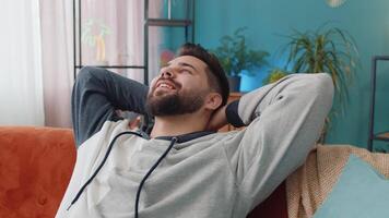 Tired young man lying down on comfortable couch, taking a rest, daytime nap relaxing falling asleep video