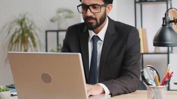 Portrait businessman freelancer at office workplace working on laptop computer sends online messages video