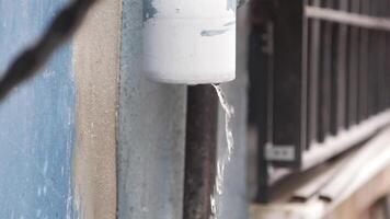 Water drips from pipe in urban setting during daylight hours video