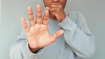 Person coughing and showing stop gesture video