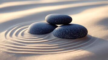 Balancing stones resting on smooth sand creating a zen atmosphere photo