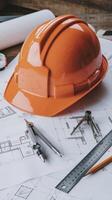 A hard hat and other construction tools on top of blueprints photo