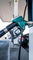A gas pump is shown with a green nozzle photo