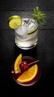 A glass of water with a cherry on top and a slice of orange photo