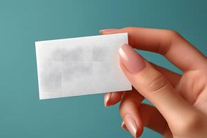 Blank Business Card Held by Hand Against Teal Background for Branding and Design photo