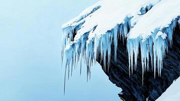 Stunning Icicles Hanging from a Snow Covered Cliff Face in Winter photo