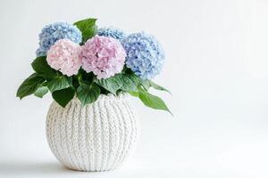 A bouquet of hydrangeas in a knitted white vase, adding a touch of elegance to decor photo
