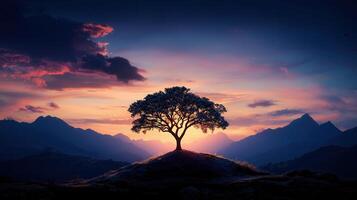 Majestic Tree Silhouetted Against Vibrant Sunset and Mountain Range Landscape photo