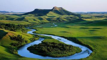 Serene River Winding Through Lush Green Rolling Hills and a Majestic Butte Landscape photo