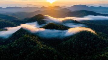 Majestic Sunrise Over Lush Green Mountains with Clouds at Dawn Aerial View photo