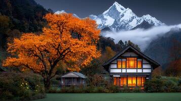 Autumnal Mountain Home Scenic House with Illuminated Windows and Vibrant Fall Foliage photo
