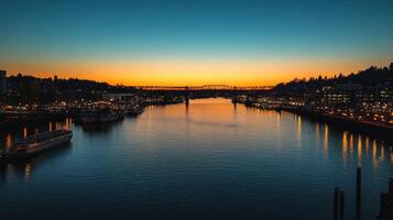 A serene sunset over a river, reflecting city lights and a bridge in the background photo