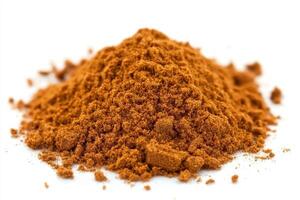 A mound of brown powder, possibly a spice or seasoning, on a white background photo