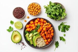 A colorful bowl of healthy ingredients including sweet potatoes, avocado, and chickpeas. photo