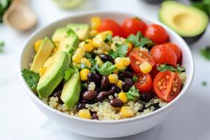 A colorful quinoa salad bowl with avocado, tomatoes, corn, and black beans photo