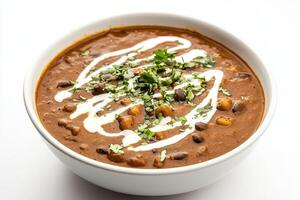 A bowl of hearty soup garnished with herbs and cream, showcasing a rich, savory texture. photo