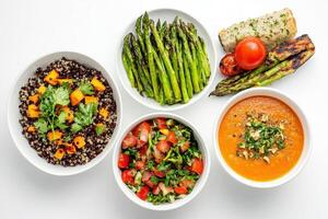 A colorful assortment of healthy dishes including salads, soup, and grilled vegetables photo