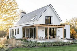 A modern farmhouse with a porch, surrounded by greenery and natural light photo