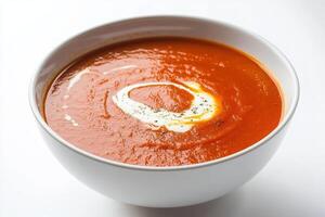 A bowl of smooth tomato soup garnished with cream. photo
