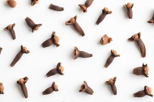 A collection of whole cloves scattered on a white background. photo