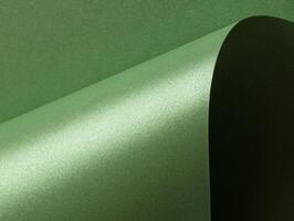 Deep forest green paper background with a smooth matte texture and subtle wavy edges. Rich basil and photo