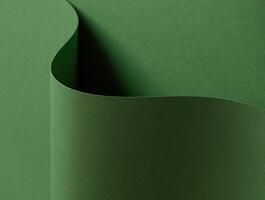 Deep forest green paper background with a smooth matte texture and layered, wavy folds. Rich moss photo