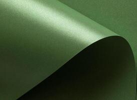 Emerald green paper background with a glossy, satin texture and shimmering wavy edges. Deep forest photo