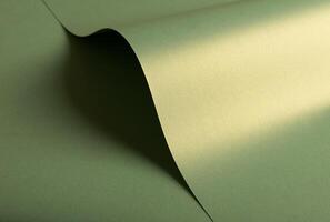 Pastel olive green paper background with a pearlescent, glossy texture and shimmering wavy edges. photo