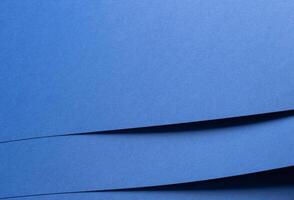 Deep sapphire blue paper background with smooth texture and overlapping curved folds. Vibrant cobalt photo