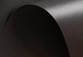 Charcoal gray paper background with a pearlescent, glossy texture. Deep graphite and gunmetal tones photo