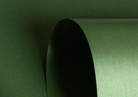 Emerald green paper background with a pearlescent, glossy texture and shimmering wavy edges. elegant photo