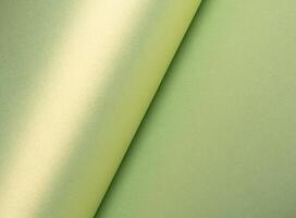 Pastel olive green paper background with a pearlescent, glossy texture. Soft sage and moss tones photo