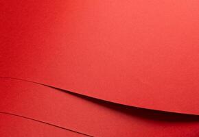 Fiery coral red paper background with a smooth texture and overlapping curved folds. Warm vermilion photo