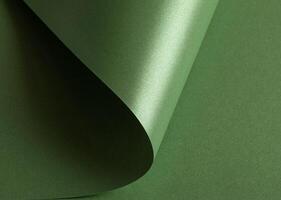 green paper background with a pearlescent, glossy texture and shimmering wavy edges. Deep forest and photo