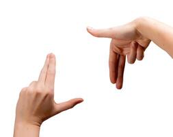 Female hands forming an L-shaped framing gesture, thumbs and index fingers creating a square to photo
