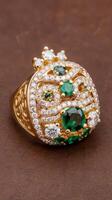 Gold ring cute with diamonds cubic zirconia emeralds and precious stones on background brown photo