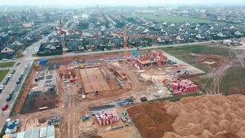 Aerial view of construction site with cranes, foundations and building materials. Residential building under construction. Progress of new development in small town video