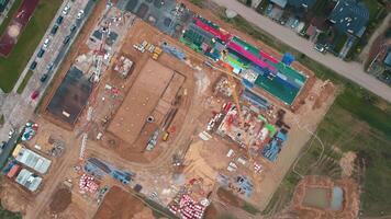 Aerial view of construction site with cranes, foundations and building materials. Residential building under construction. Progress of new development in small town video