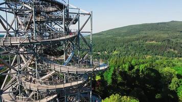 Aerial view of Sky Walk spiral observation tower in Sweradow Zdroj, Poland, surrounded by green forests. Popular tourist attraction with breathtaking panoramic views of surrounding mountains video