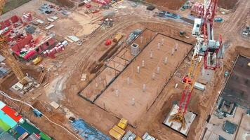 Aerial view of construction site with cranes, foundations and building materials. Residential building under construction. Progress of new development in small town video