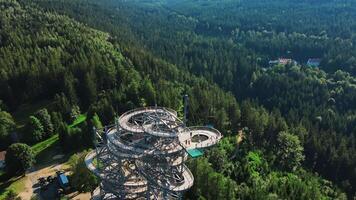 Aerial view of Sky Walk spiral observation tower in Sweradow Zdroj, Poland, surrounded by green forests. Popular tourist attraction with breathtaking panoramic views of surrounding mountains video