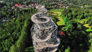 Aerial view of Sky Walk spiral observation tower in Sweradow Zdroj, Poland, surrounded by green forests. Popular tourist attraction with breathtaking panoramic views of surrounding mountains video