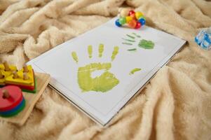 Bright Artwork Display of Children's Handprint on Soft Blanket with Toys Nearby photo
