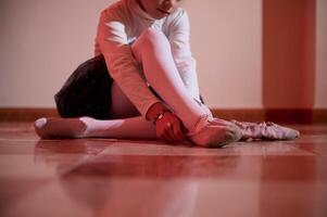 Young Ballerina Preparing for Dance Performance in Elegant Attire photo
