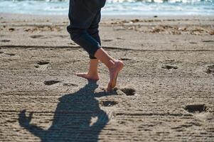 Barefoot Steps on Sunny Beach Appealing to Summer Vibes and Relaxation photo