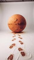 A large brown ball with footprints in the sand photo